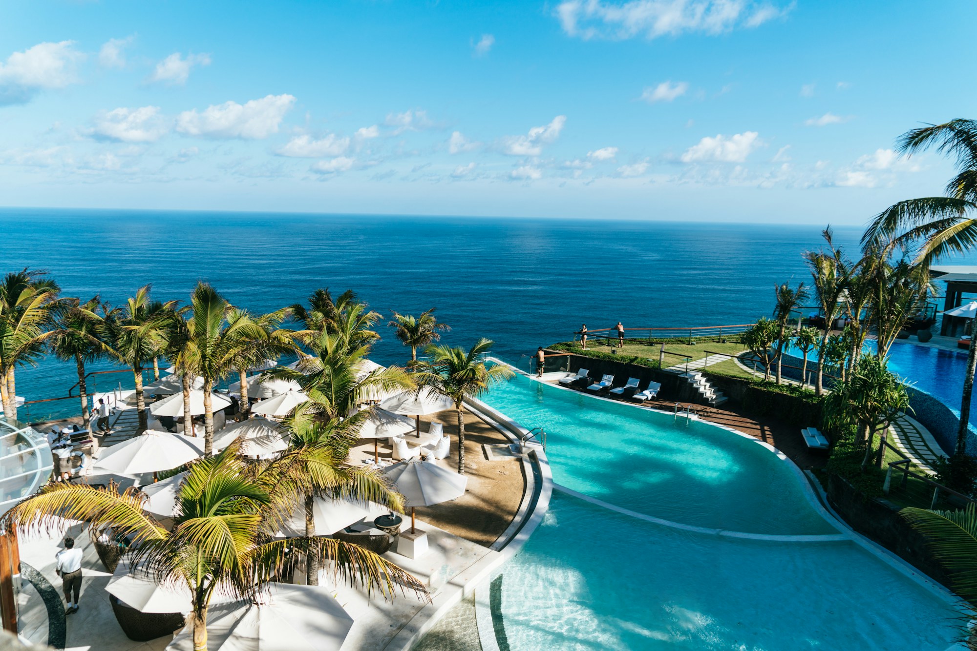 Sunlit residential pool with clear water and tile waterline at midday