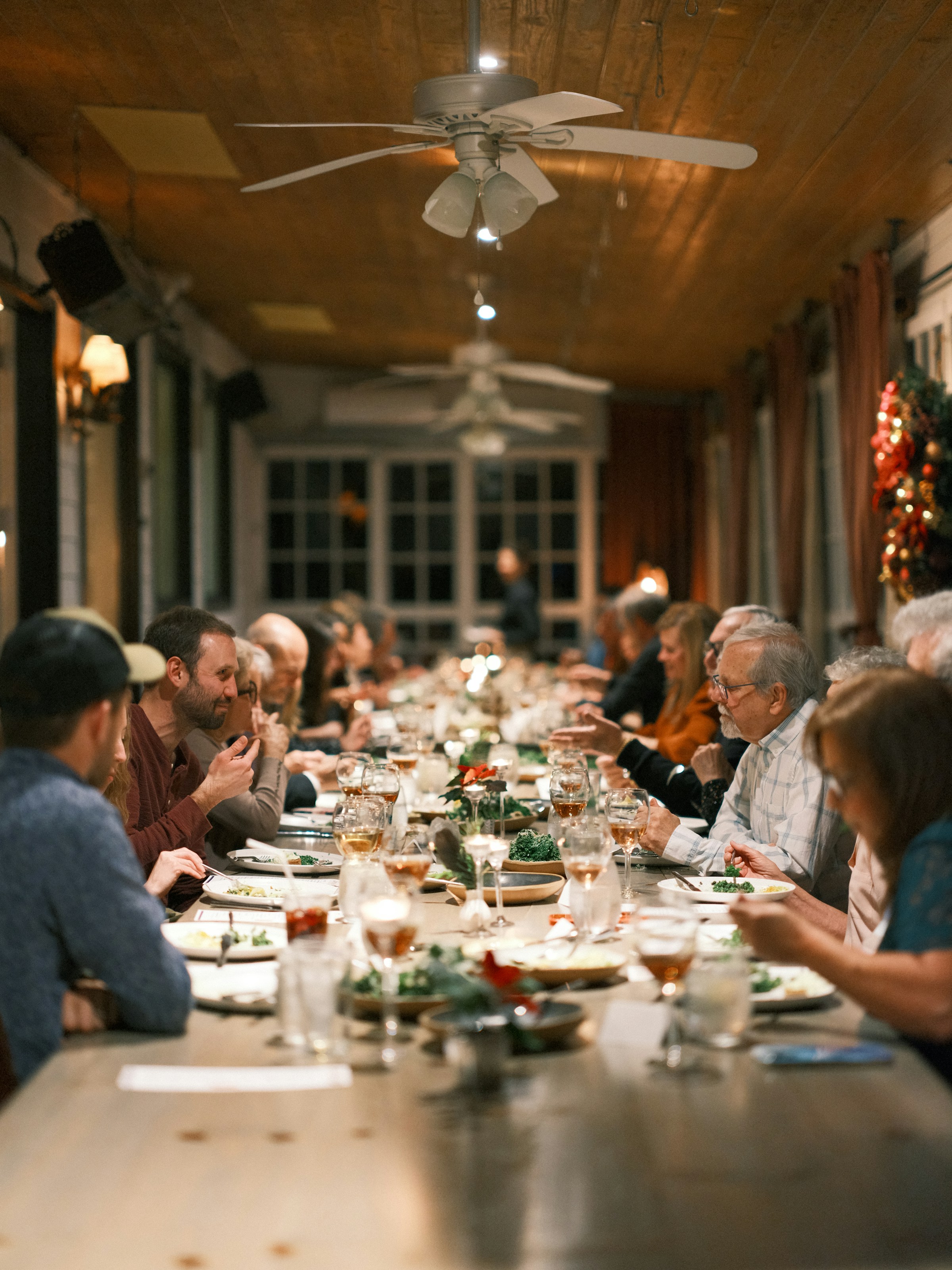 The private back room set up as one long communal table, guests seated along both sides under a wood ceiling