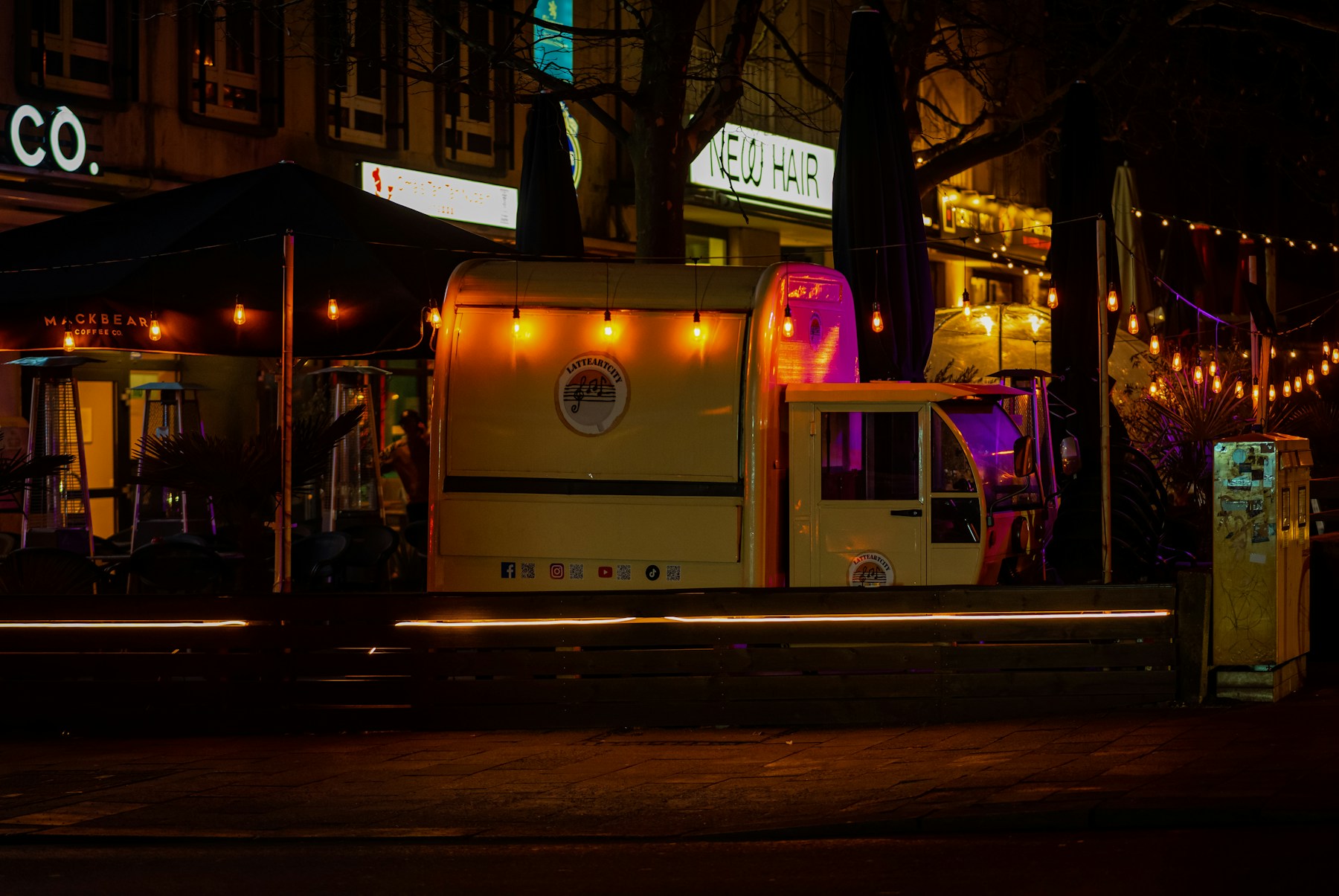 Gutter Tacos truck parked on a city street at night, string lights overhead